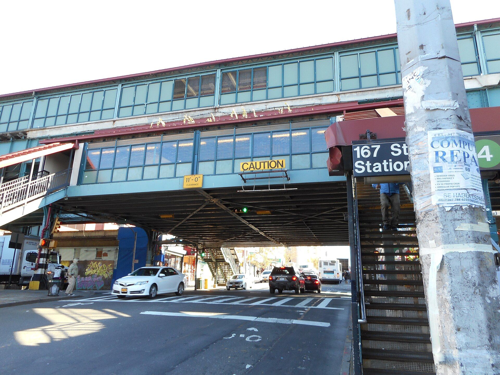 An elevated train station spanning a Bronx avenue, with steel stairs rising from the sidewalk, for a reading guide to Richard Joseph Spinelli