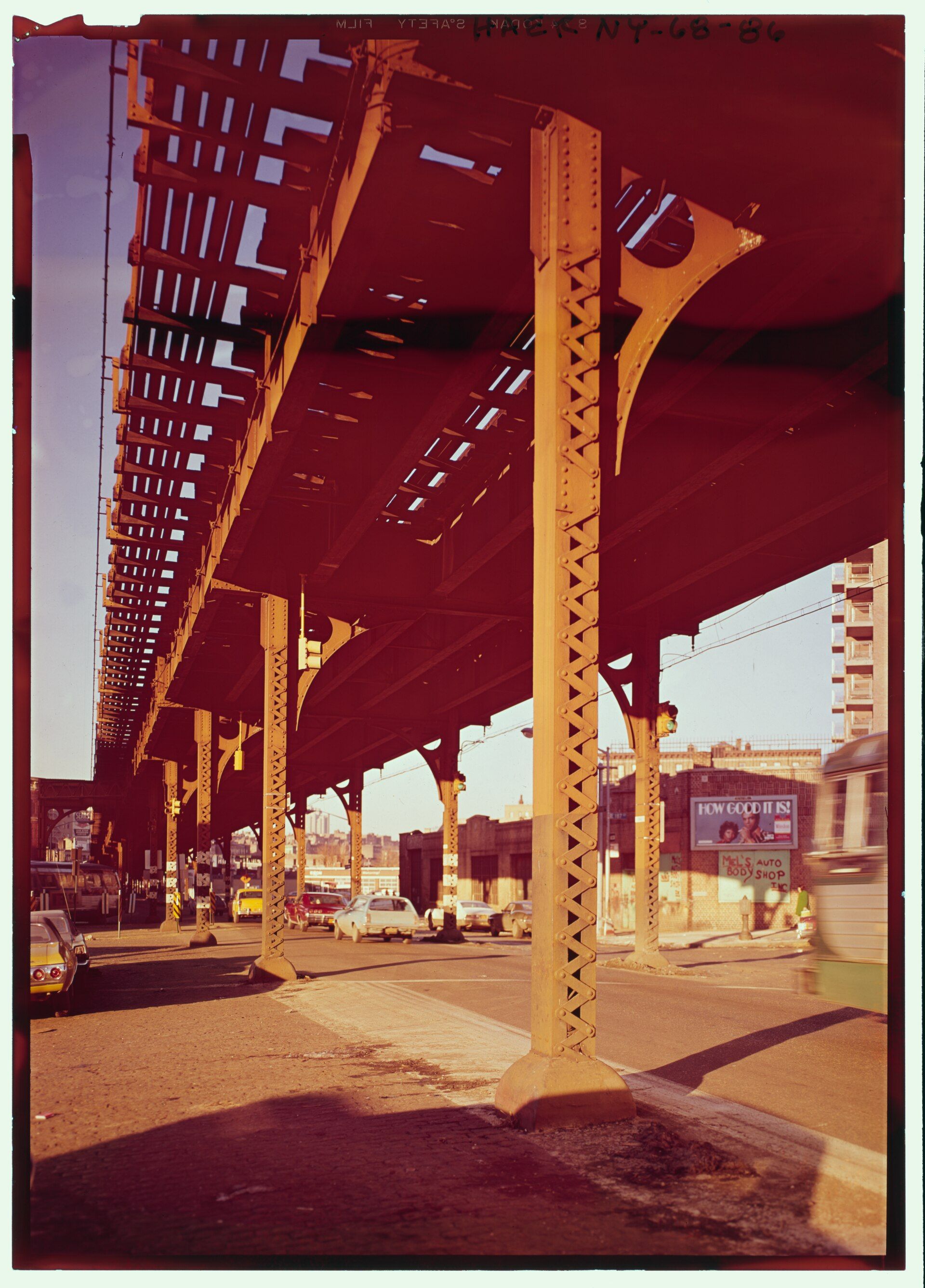 Riveted steel columns and girders of an old elevated rail line over a Bronx avenue in low sun, for a series by Richard Joseph Spinelli